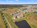 An aerial view of a house and surrounding community near a lake at 8208 Carrhill Pl, Parrish, FL 34219