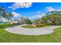 View of the home from the side showing the circular paved driveway, mature landscaping, and beautiful home at 935 Bayshore Rd, Nokomis, FL 34275