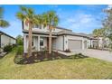 Two-story house with gray siding, three-car garage, and palm trees at 1012 Fernleaf Run, Bradenton, FL 34212