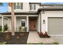 Front entrance with a walkway, landscaping, and a two-car garage at 1012 Fernleaf Run, Bradenton, FL 34212