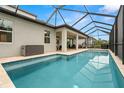 Screened-in pool with a covered patio and beautiful landscaping at 1012 Fernleaf Run, Bradenton, FL 34212