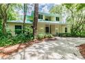 Two-story house with light yellow siding, green roof, and a covered porch at 1130 Anclote Rd Rd, Tarpon Springs, FL 34689