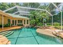 Relaxing screened pool with a waterfall feature and plenty of lounge space at 1130 Anclote Rd Rd, Tarpon Springs, FL 34689