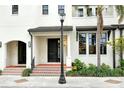 Townhome entrance with tiled steps, black door, and landscape at 1273 Boulevard Of The Arts, Sarasota, FL 34236