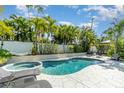 Inviting kidney-shaped pool with spa, surrounded by lush tropical landscaping at 1507 91St Nw Ct, Bradenton, FL 34209