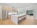 Modern kitchen with large island, stainless steel appliances, and light wood cabinets at 2008 Tocobaga Ln, Nokomis, FL 34275