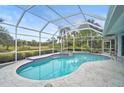 Relaxing kidney-shaped pool with a covered patio overlooking a pond at 2008 Tocobaga Ln, Nokomis, FL 34275