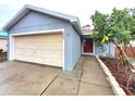 Gray house with beige garage door and a landscaped front yard at 2309 30Th W Ave, Bradenton, FL 34205