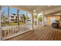 Relaxing front porch with wood flooring, white railings, and tropical views at 306 55Th St, Holmes Beach, FL 34217