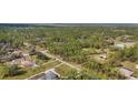 An aerial view showing the property's location in a wooded area with a nearby road at 3340 Ulman Ave, North Port, FL 34286