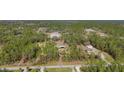 Expansive aerial view of a wooded property with various structures and a long driveway at 3340 Ulman Ave, North Port, FL 34286