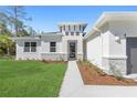 Front entrance with walkway and landscaping; modern white house with stone accents at 3415 Nadasky Ave, North Port, FL 34288