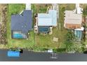 Drone view showcasing multiple houses, pools, and canal access at 3438 Yukon Dr, Port Charlotte, FL 33948