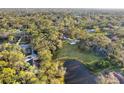 Aerial view of a home and a pond surrounded by lush greenery and mature trees at 3501 Sunbeam Dr, Sarasota, FL 34240