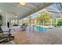 Screened-in pool area with tiled flooring, ceiling fans, and outdoor seating at 3501 Sunbeam Dr, Sarasota, FL 34240