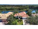 Single-Gathering home with lake view, showcasing backyard and landscaping at 3716 Eagle Hammock Dr, Sarasota, FL 34240