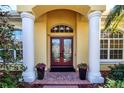 Elegant entryway with double doors and columns, featuring brick flooring at 3716 Eagle Hammock Dr, Sarasota, FL 34240