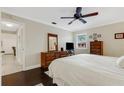 King-size bed, dark hardwood floors, ceiling fan, and view of hallway at 3815 59Th W Ave # 3815, Bradenton, FL 34210