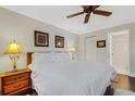 King-size bed, dark hardwood floors, ceiling fan, and bathroom access at 3815 59Th W Ave # 3815, Bradenton, FL 34210