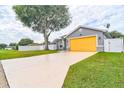 Gray house with a yellow garage door and a long driveway at 3906 Chaucer Ln, Sarasota, FL 34241