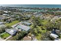 An aerial view shows a charming light blue house with a pool in a residential area at 401 Shore Rd, Nokomis, FL 34275