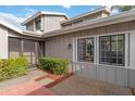 Condo's exterior features a screened entryway and manicured landscaping at 4555 Forest Wood Trl # 23, Sarasota, FL 34241