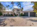 Modern home exterior with two-car garage and tropical landscaping at 512 Bayview Pl, Anna Maria, FL 34216