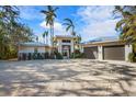 Front view of a contemporary home with a two car garage at 512 Bayview Pl, Anna Maria, FL 34216