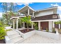 Modern two-story home with tropical landscaping and walkway at 541 Edlee Ln, Longboat Key, FL 34228