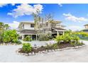 Two-story home with modern design and lush tropical landscaping at 541 Edlee Ln, Longboat Key, FL 34228