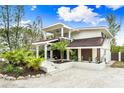 Modern two-story home with tropical landscaping and walkway at 541 Edlee Ln, Longboat Key, FL 34228