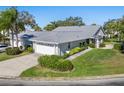 Aerial view showcasing a single-story house with a gray roof, driveway and landscaping at 5532 Country Club Way, Sarasota, FL 34243