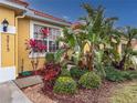 Landscaped area with tropical plants near the house entrance at 5715 Spanish Point Ct, Palmetto, FL 34221