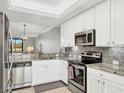 Modern kitchen with white cabinets, granite counters, and stainless steel appliances at 6819 Grand Estuary Trl # 102, Bradenton, FL 34212