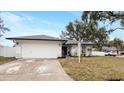 White house with gray roof, landscaping, and a two-car garage at 7664 39Th Street E Cir, Sarasota, FL 34243