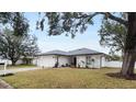 Landscaped yard with a white house and gray roof at 7664 39Th Street E Cir, Sarasota, FL 34243