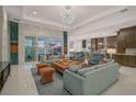 Open-concept living room with a view of the pool, plush seating and modern decor at 8261 Grande Shores Dr, Sarasota, FL 34240