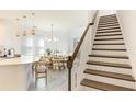 Modern kitchen with island, white cabinets, and staircase at 8612 Evening Dr, Sarasota, FL 34241