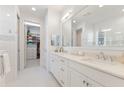 Elegant bathroom with double sinks, a large mirror, and a walk-in closet at 883 Seascape Pl, Sarasota, FL 34240