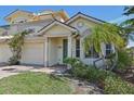 Two-story house with light yellow walls, green door, and a two-car garage at 1110 Beachcomber Ct # 1, Osprey, FL 34229