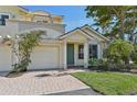 Two-story house with light yellow walls, green door, and a two-car garage at 1110 Beachcomber Ct # 1, Osprey, FL 34229