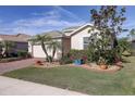 House with green roof, brick driveway, and lush landscaping, including palm trees at 11698 Anhinga Ave, Venice, FL 34292