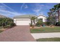 Well-maintained house with green tile roof, landscaping, and brick driveway at 11698 Anhinga Ave, Venice, FL 34292