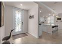 Bright entryway with decorative glass door and view into kitchen at 12550 Ghiberti Cir # 101, Venice, FL 34293