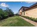 Landscaped side yard with brick walkway leading to back of house at 12550 Ghiberti Cir # 101, Venice, FL 34293