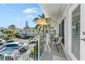 Private balcony with patio furniture, overlooking parking area and tropical foliage at 521 W Venice Ave # 22, Venice, FL 34285