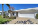 Condo exterior showcasing a neatly landscaped front yard and a double-car garage at 6810 9Th W Ave, Bradenton, FL 34209