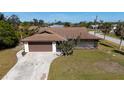 Single-story house with brown roof, driveway, and yard at 7450 Ebro Rd, Englewood, FL 34224