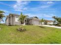 Exterior view of house with lush lawn and palm trees at 10442 Winnipeg St, Port Charlotte, FL 33981