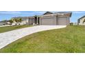 House exterior showcasing a paver driveway and landscaping at 10442 Winnipeg St, Port Charlotte, FL 33981